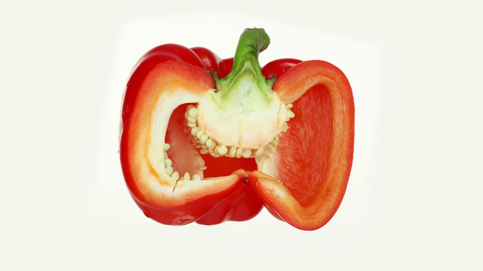 Red ripe pepper cut in half rotate on gray background