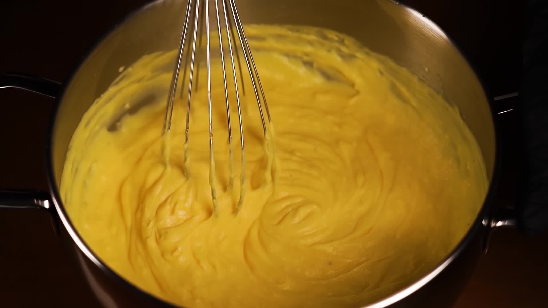 Custard in the pot is mixed by hand