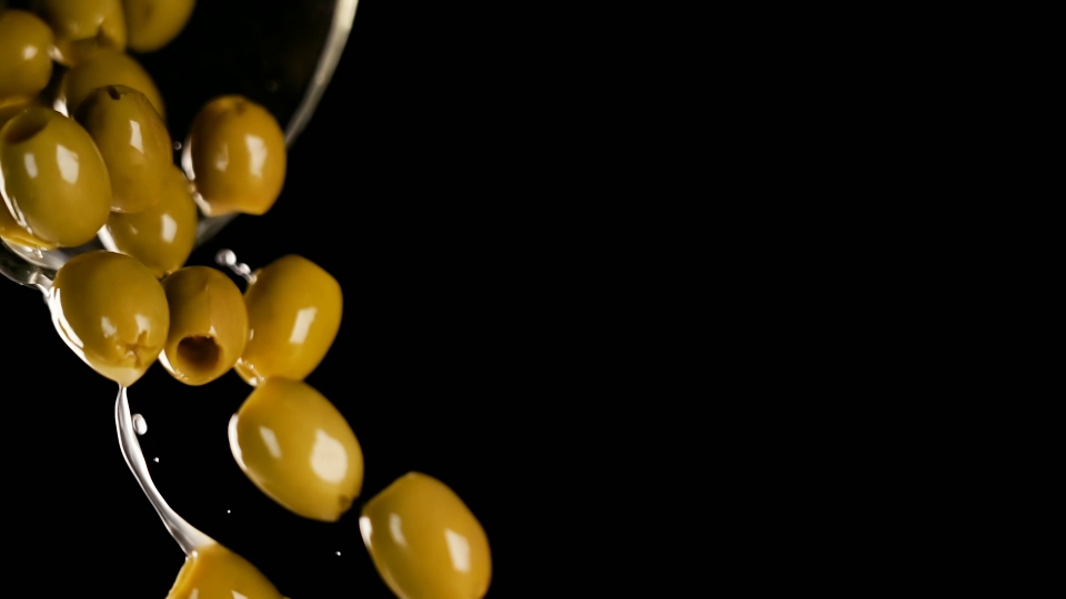 Olives are poured on a black background