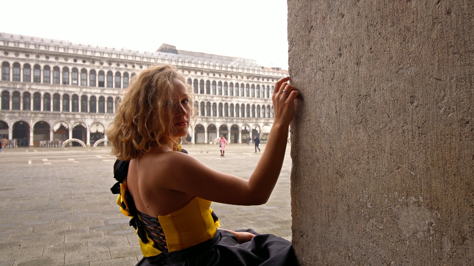 La signora in vestito giallo nero alla moda posa per la macchina fotografica