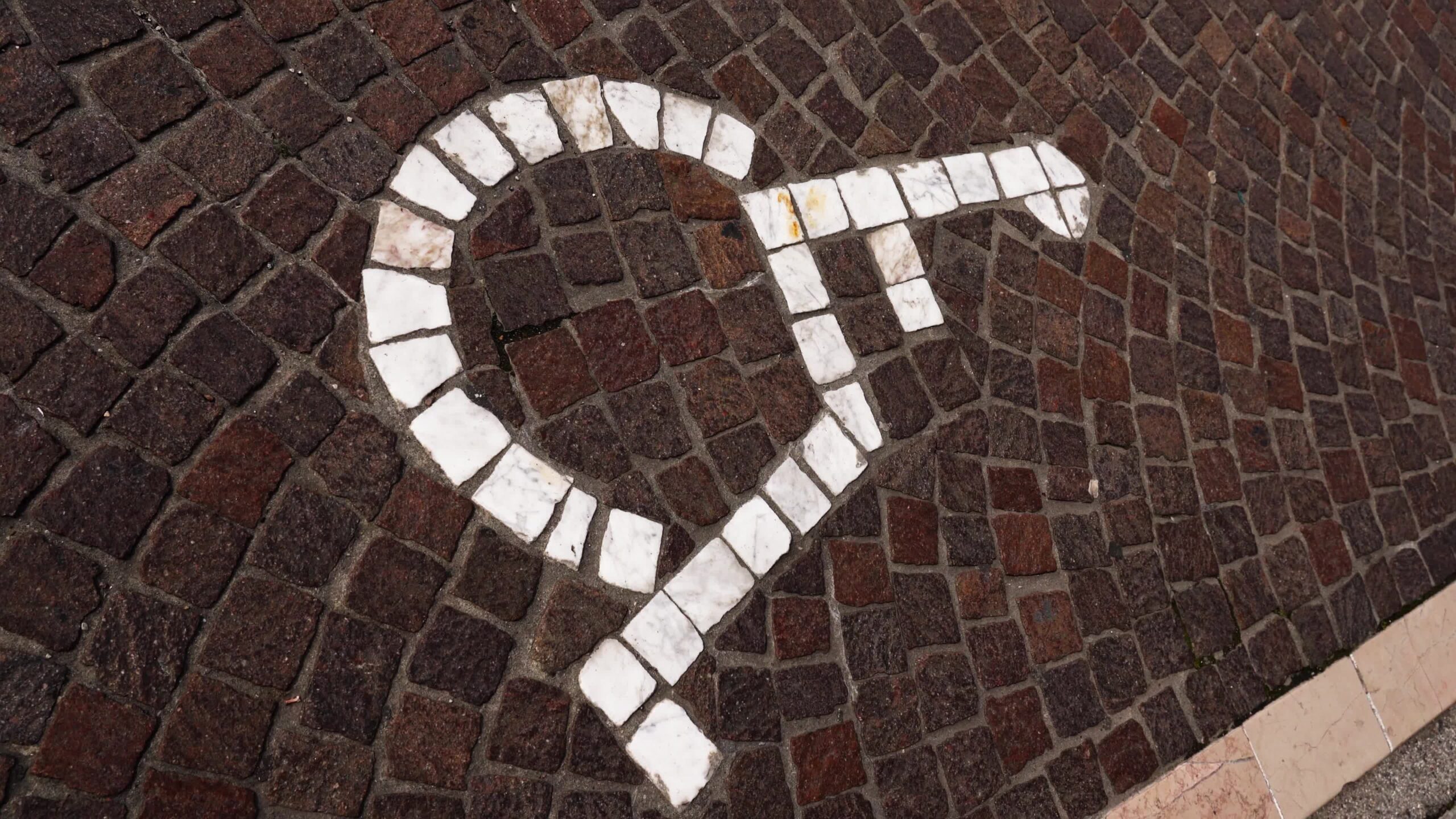 Motion over disabled sign tiled with stones on pavement