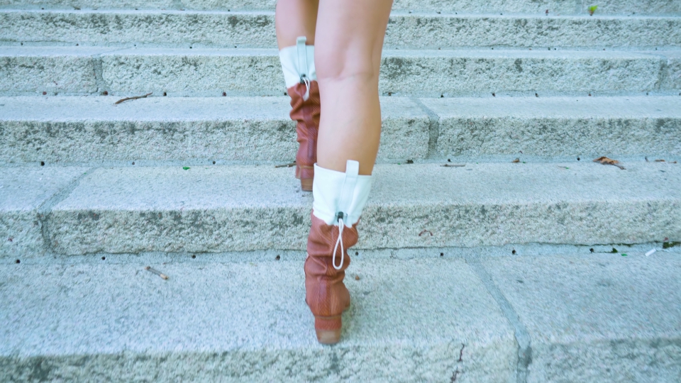 Woman tourist climbs stairs with wide concrete steps