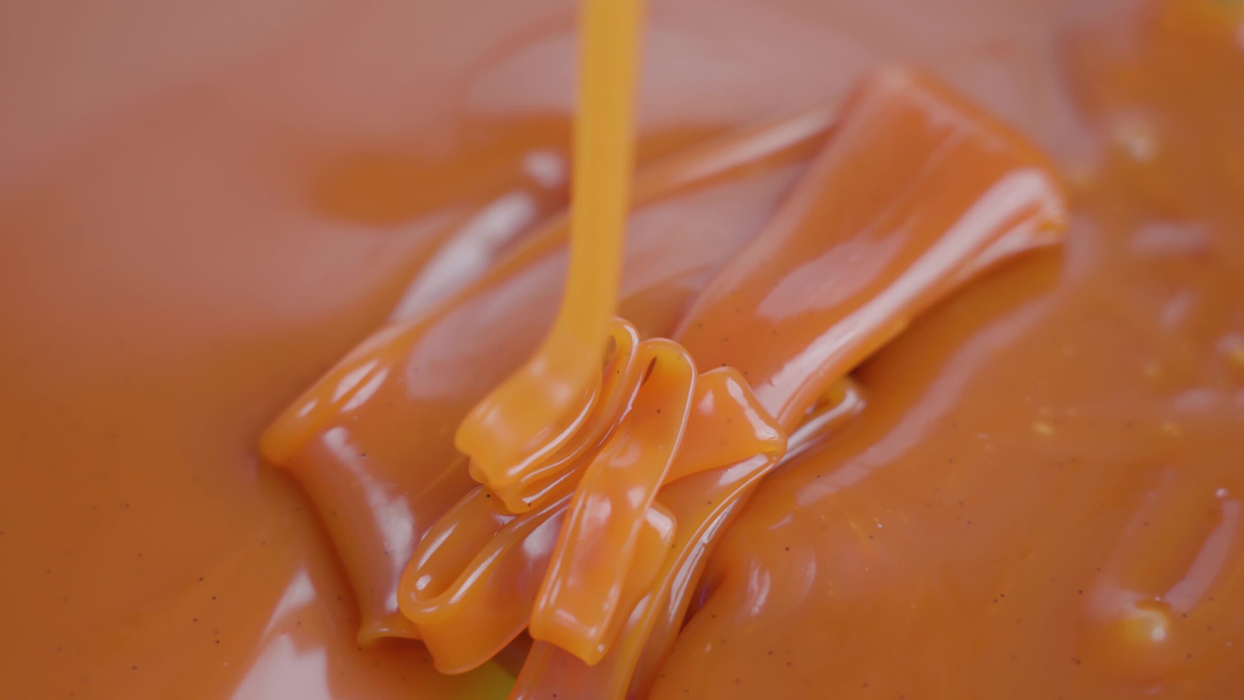 Tasty nutty brown colored caramel sauce falls in mold