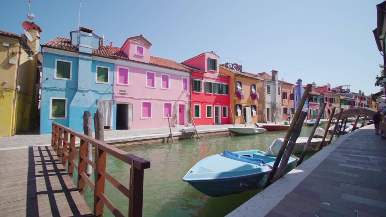 Le case stanno lungo il canale d’acqua con barche e ponte