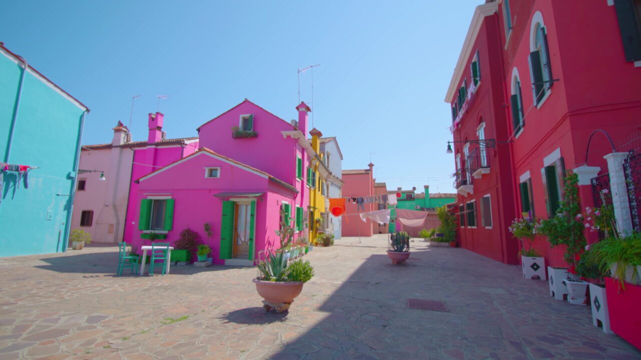 Colorful houses with shutters and flowerpots with plants