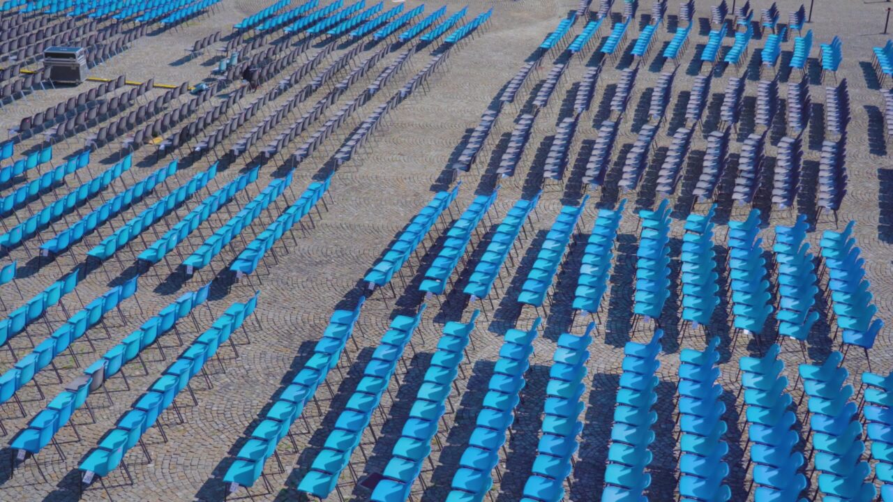 Long rows of blue plastic chairs for spectators in town