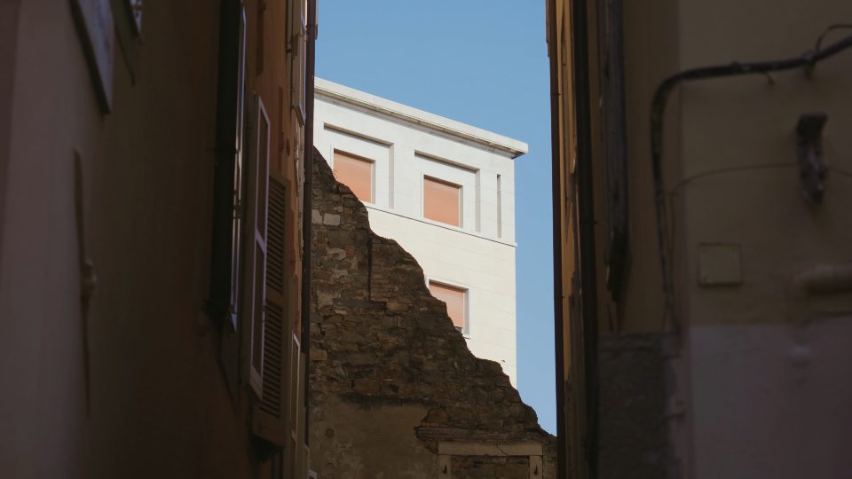 White building corner looks out of ruined ancient structure