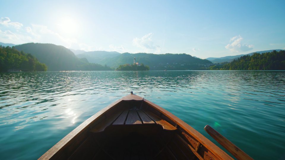 View of small island opens from wooden boat on Bled lake