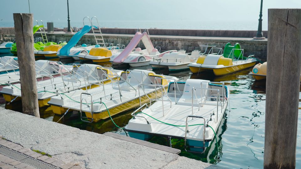 Colorful fishing and tour boats moored in port of lake Garda