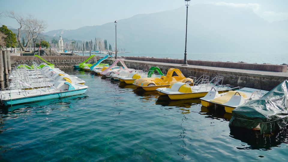 Colorful touristic boats moored to bank against mountains