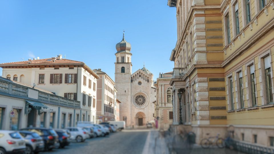 Edifici d’epoca e cattedrale con il cielo azzurro a Trento