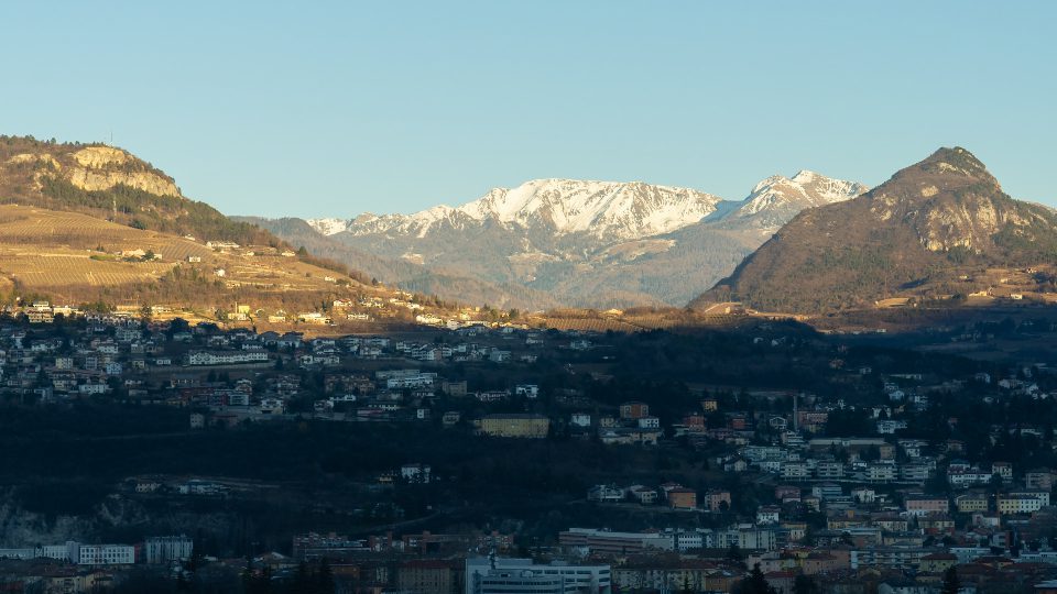 Shadow covers town Trento against giant forestry mountains