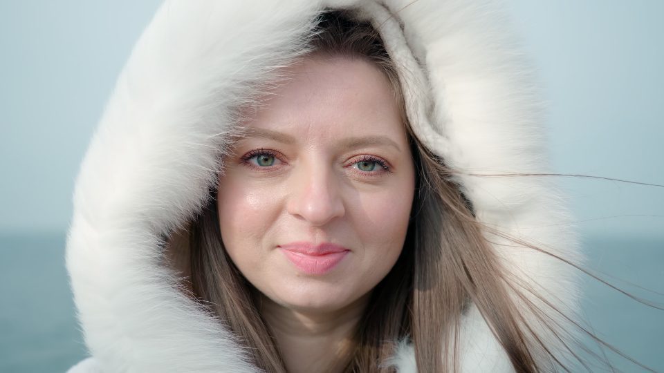 Portrait of young woman in white hood on blurred background