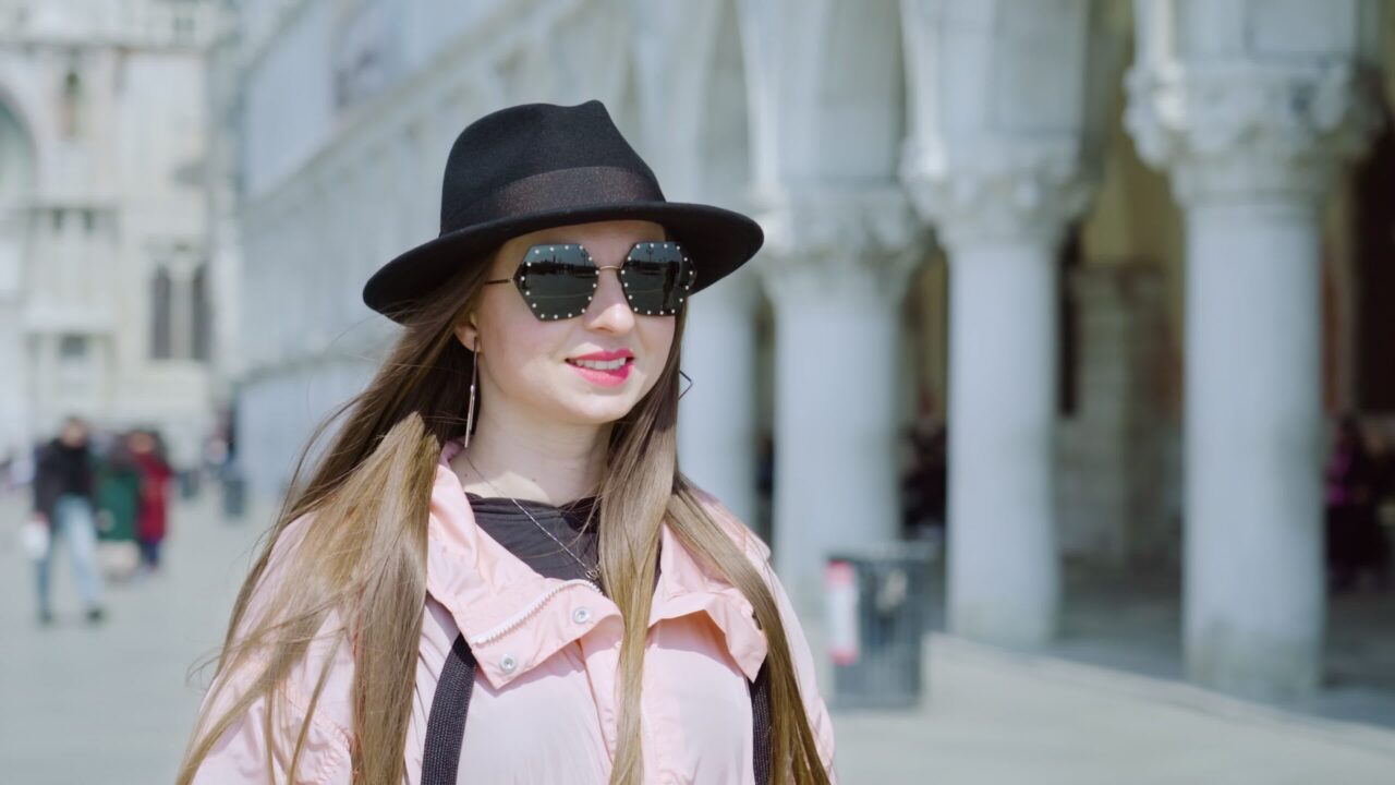 Stylish woman stands on St. Mark Square posing for photo