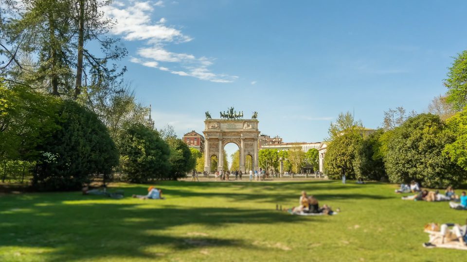 Triumphal Arch of Peace in city park with people on lawn