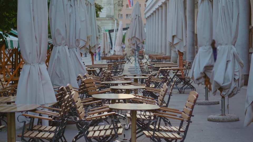 File di tavoli e sedie in legno in un accogliente caffè di strada