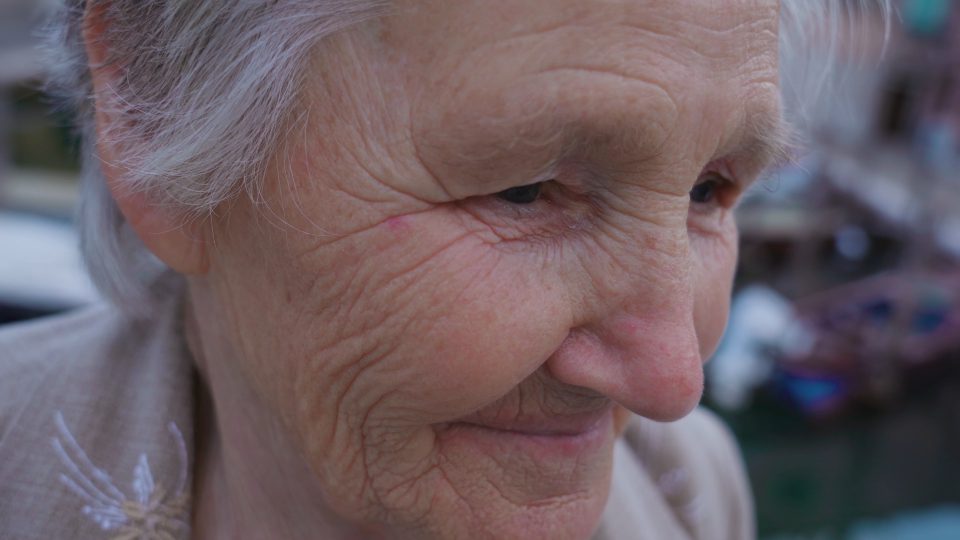 Elderly woman traveler smiles enjoying view of Chioggia