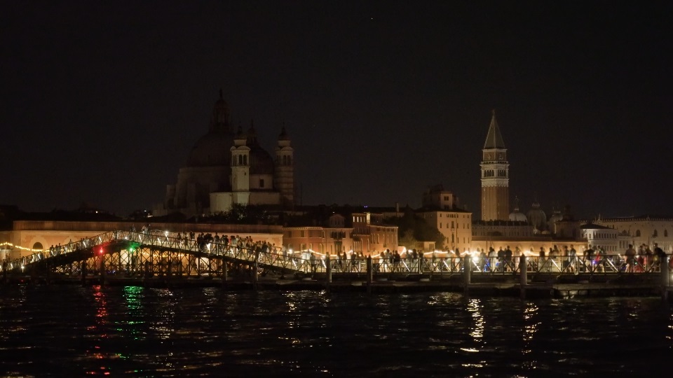 La gente cammina sul lungo ponte di barche durante la festa del Redentore