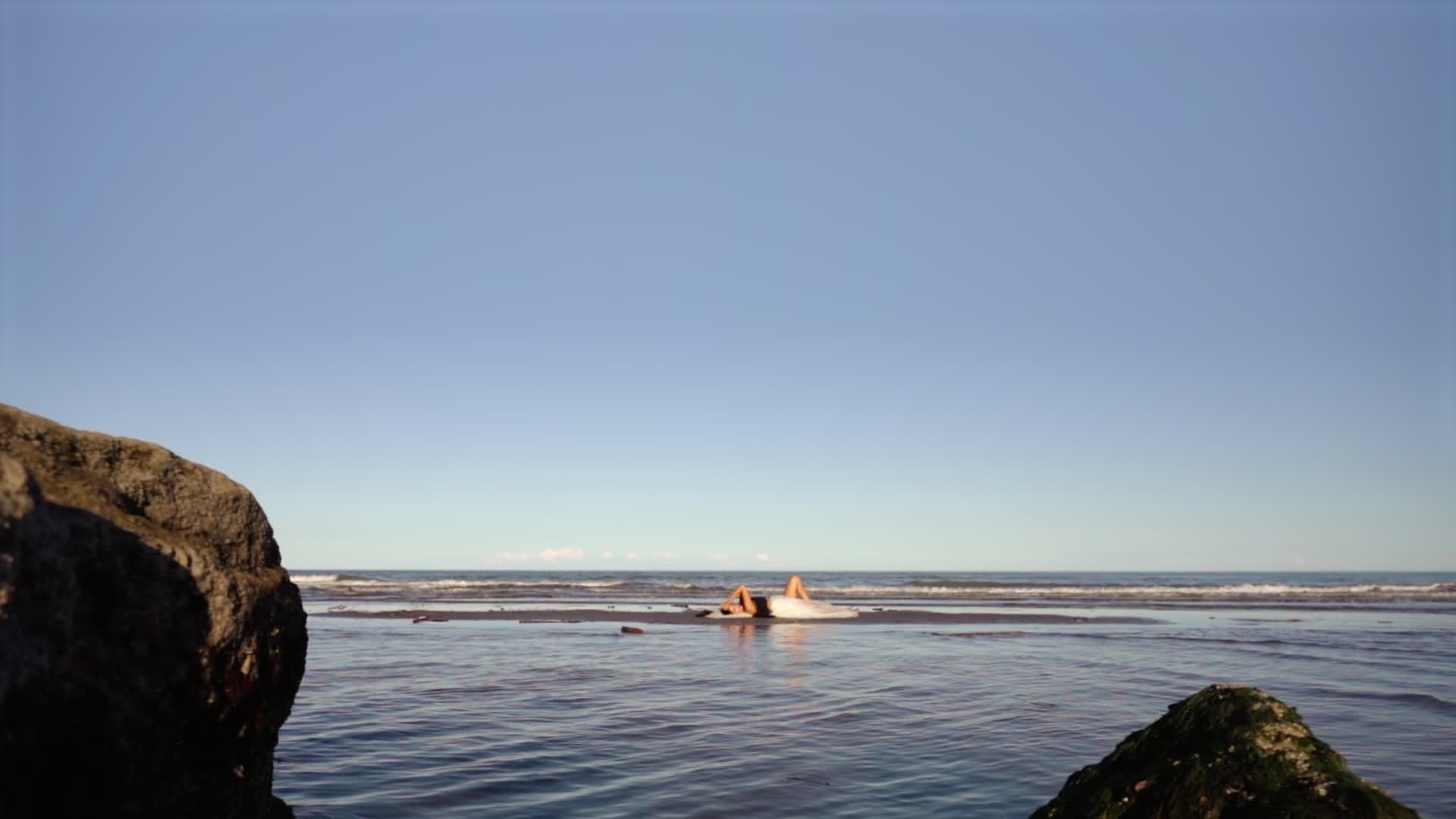 Woman lying by the sea