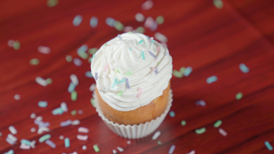 Cake with cream on top is covered with coconut flakes