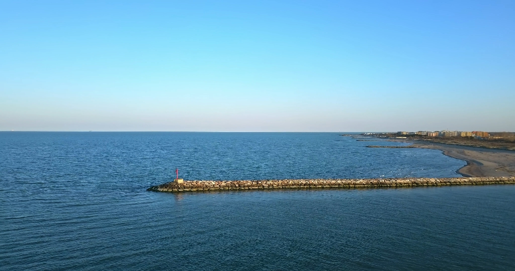 Spiaggia con una diga e molte piccole dighe in pietra e mattoni