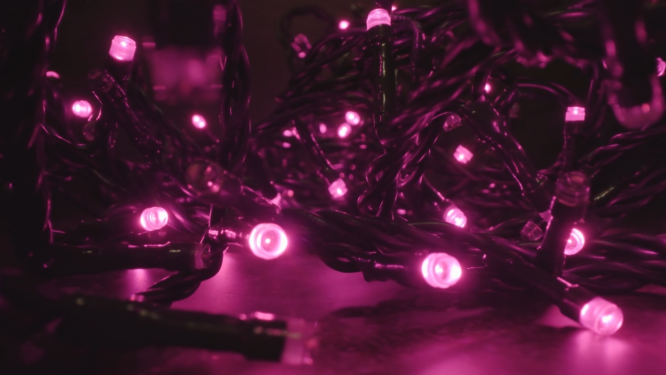 Glowing purple fairy lights tangled coil in dark room