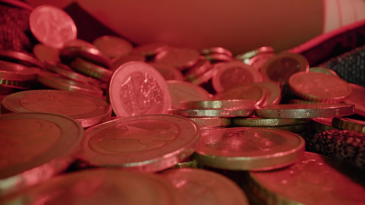 Motion over scattered golden euro coins on fabric sheet