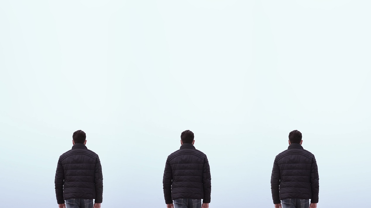 Three men walk with their backs