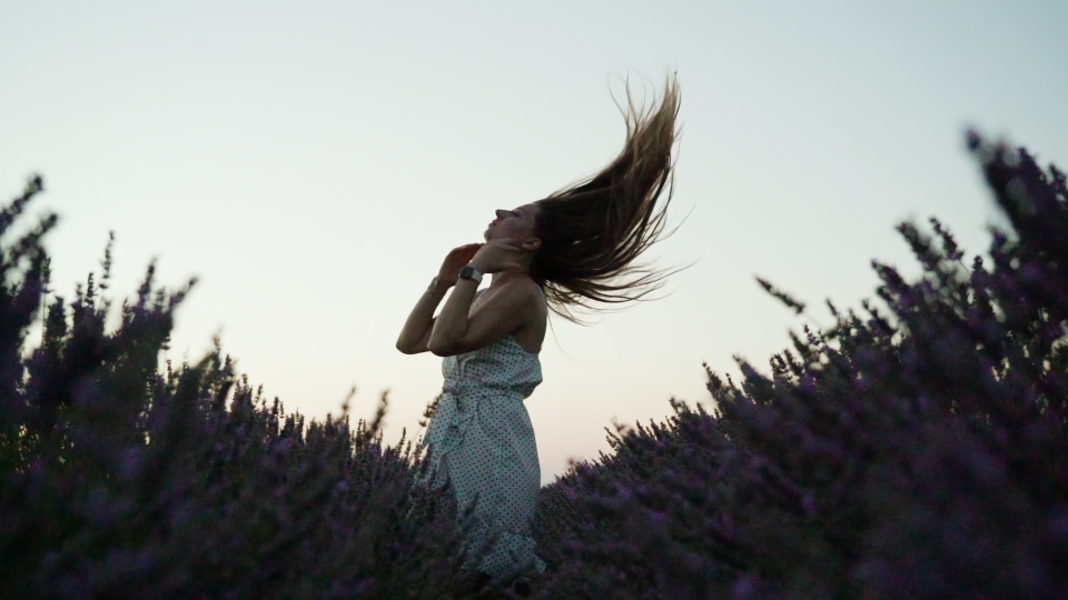 Woman tosses hair in lavender