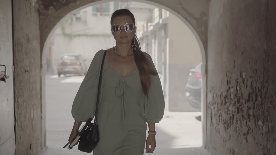 Woman with summer dress and elegant handbag walks