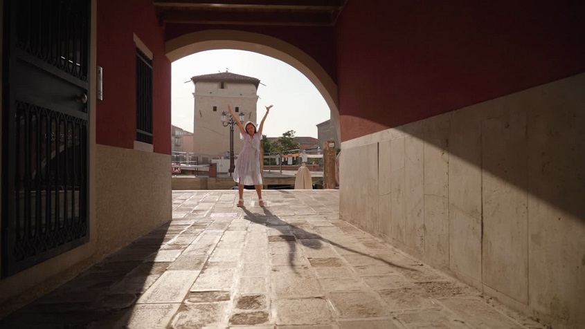 Elegance and Rhythm: Woman Dancing in a Summer Dress on the Streets of Venice