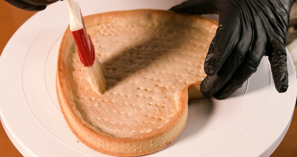 La crostata a forma di cuore è ricoperta di crema