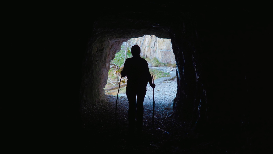 La persona cammina all’interno di una grotta buia