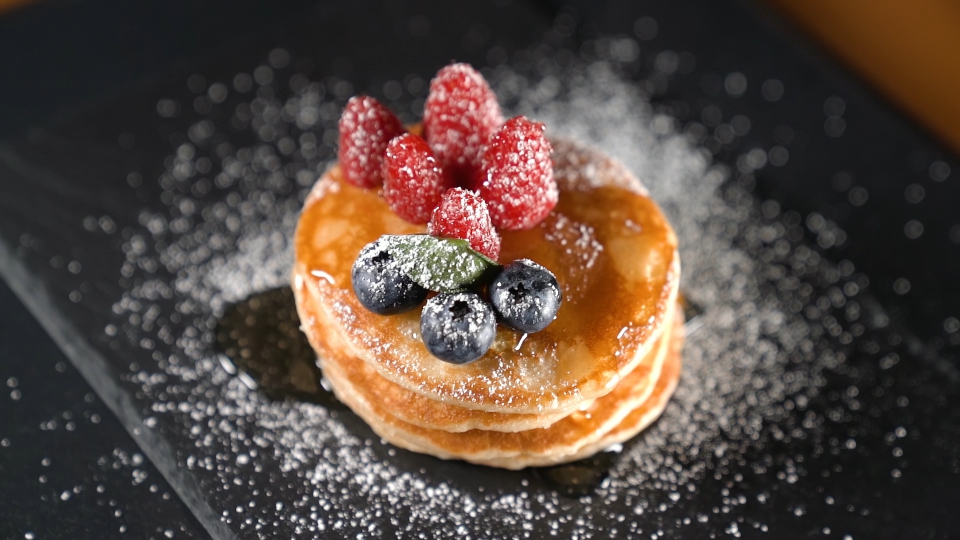 Timelapse of fruit and syrup over Pancakes