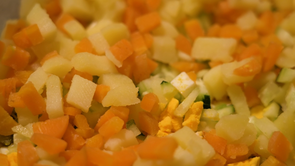 Salad in the foreground of carrots and potatoes