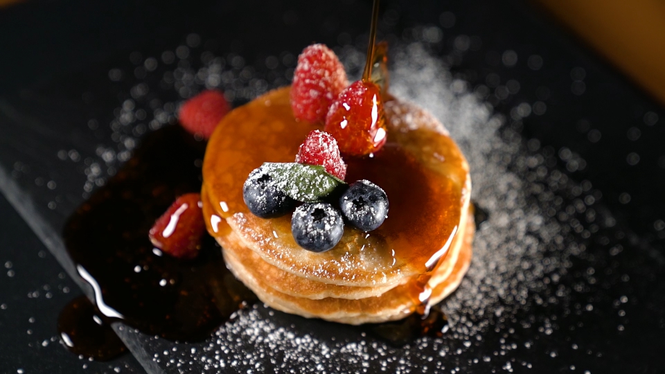 Syrup is poured in slow motion over the pancake