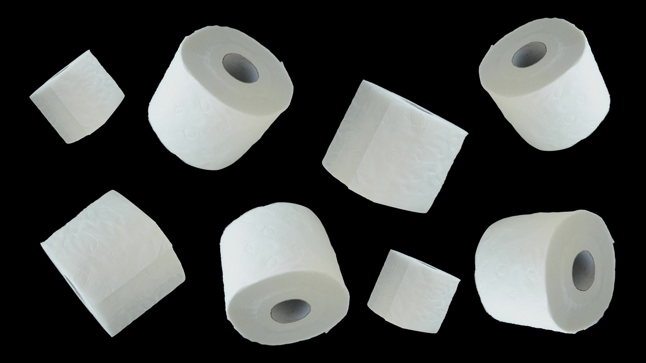 Rolls of toilet paper fly on black background