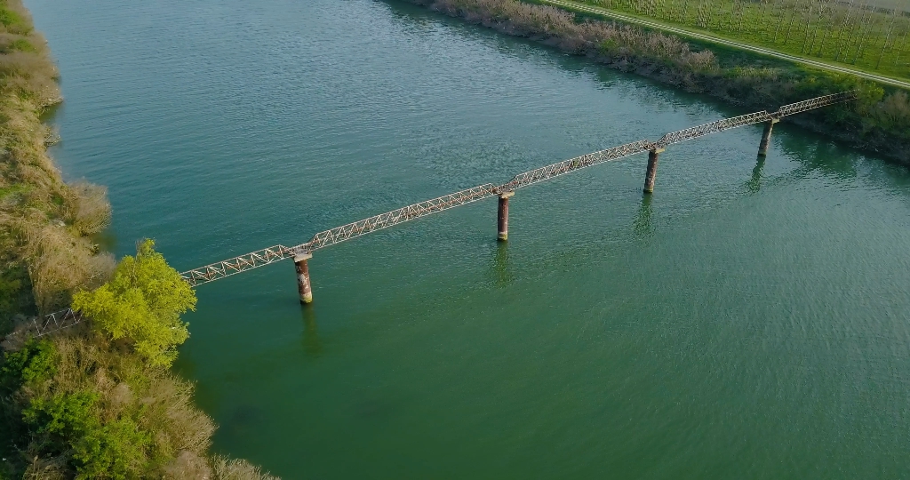 Old metal pipe runs over a river