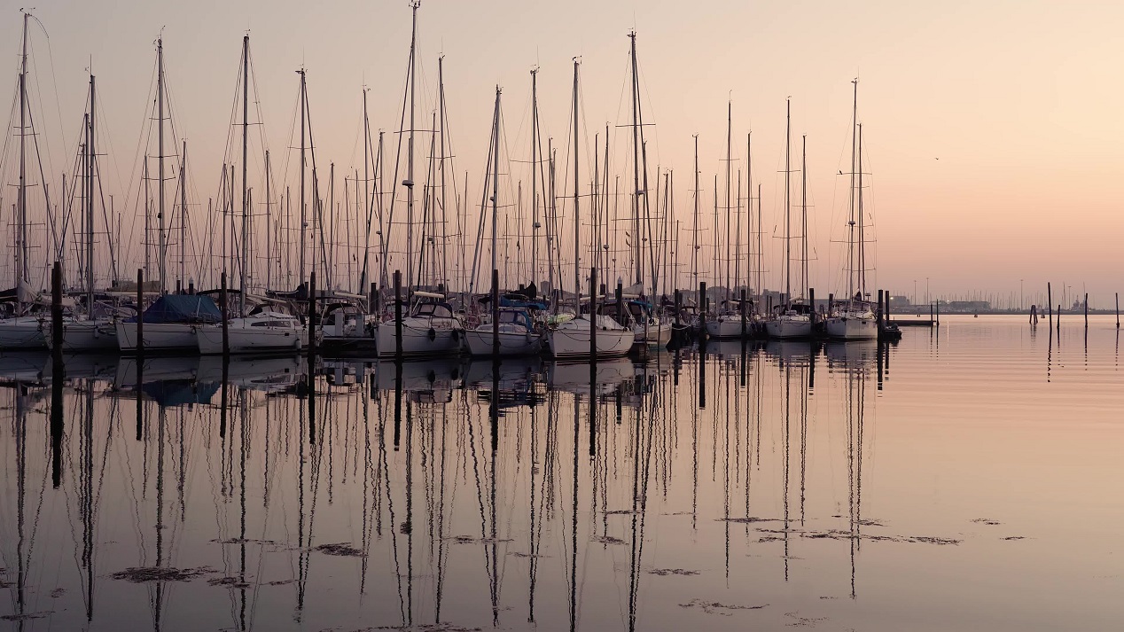 Barche a vela parcheggiate con riflessi nell’acqua