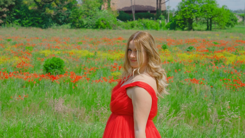 La donna con il vestito rosso si muove nel verde della natura