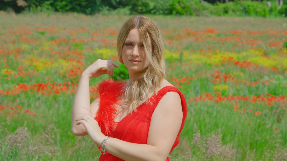 La donna elegante si muove davanti al campo rosso dei papaveri