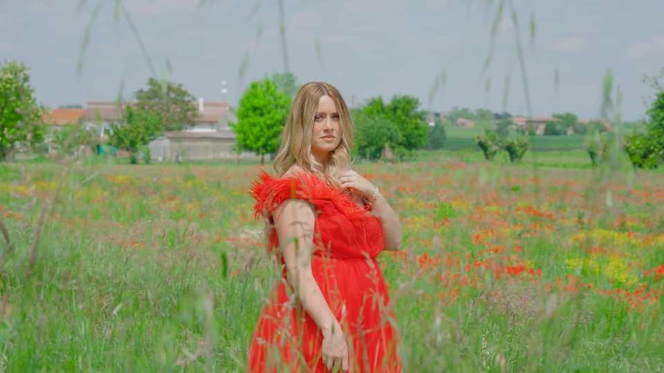 Young girl with red dress walks among the nature