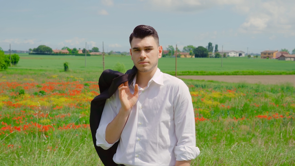 Ragazzo con camicia bianca in mezzo alla natura