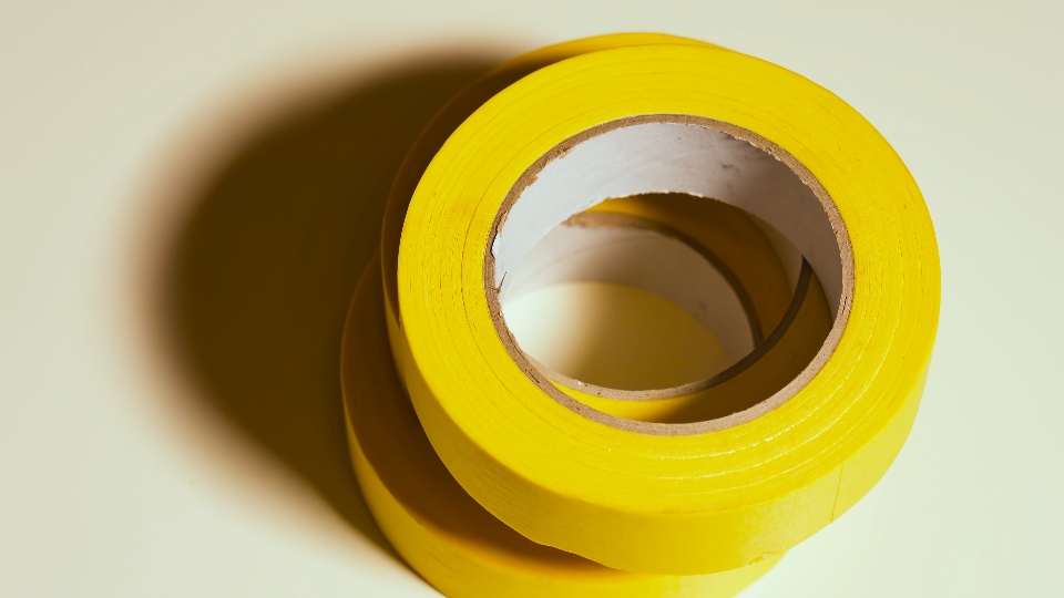 Yellow sticky tape rotates on gray background