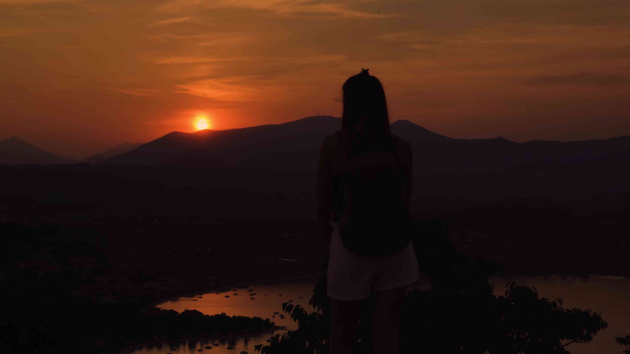 Donna al tramonto scuro in montagna