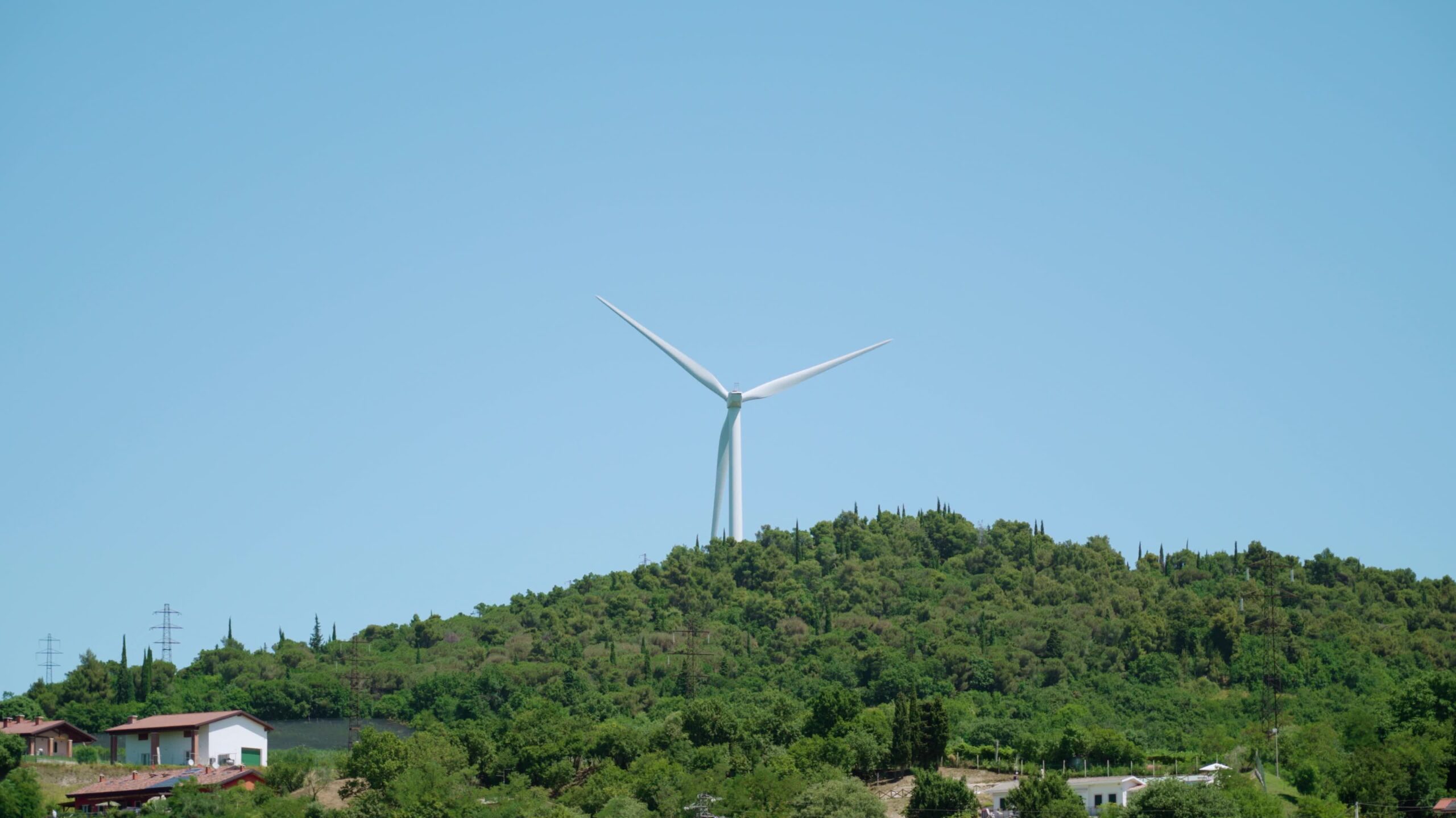 Wind turbine rotates behind the hill