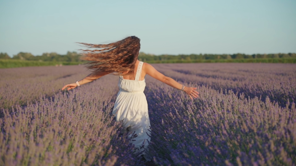 Happy woman rotates in slow motion with flying hair