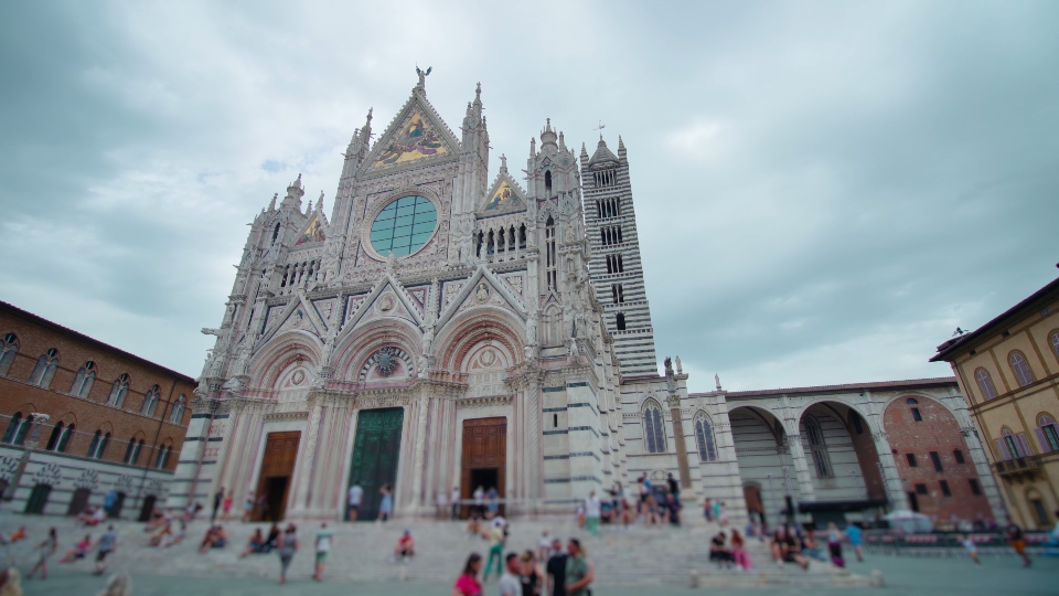 Piazza di Siena con persone che camminano attorno il Duomo