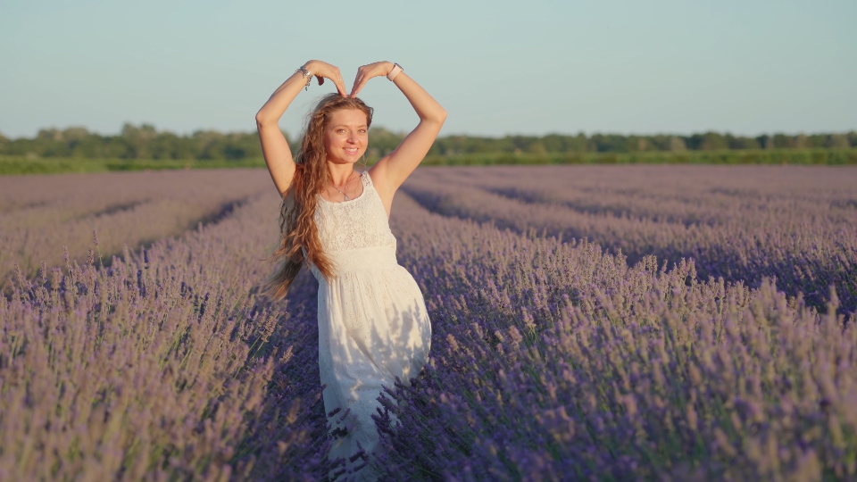 Woman shows heart sign with arms