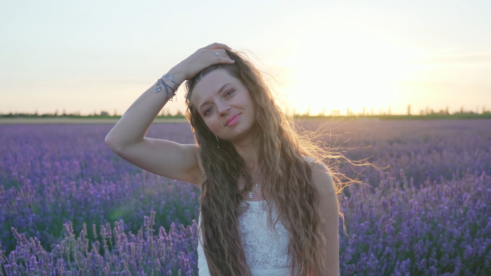 Capelli della donna svolazzano al vento al tramonto